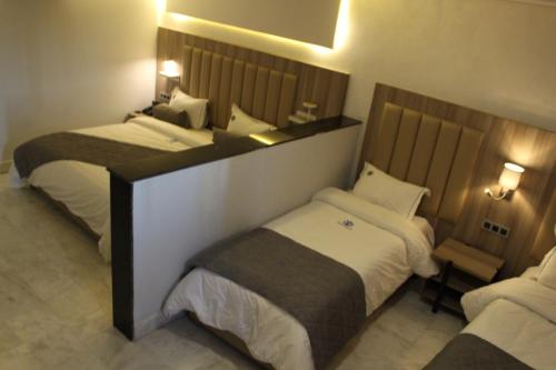 a hotel room with two beds in a room at Hôtel La Perla in Al Hoceïma