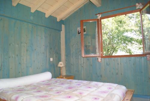 une chambre bleue avec un lit et une fenêtre dans l'établissement Chalets Etchemendigaraya, à Suhescun
