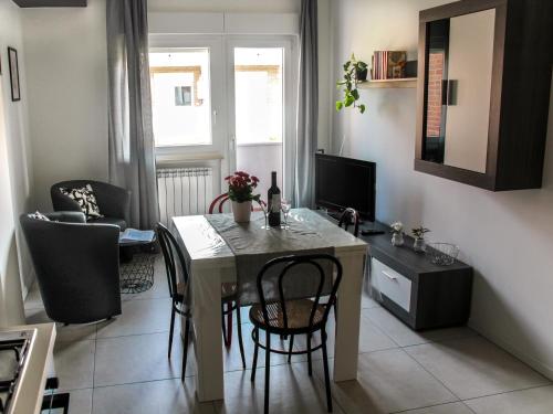 a living room with a table with chairs and a television at Casa Felicità in Udine