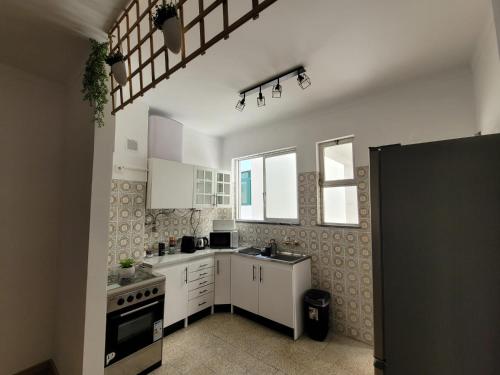 a kitchen with white cabinets and a stove at Reis Turismo 2 in Faro