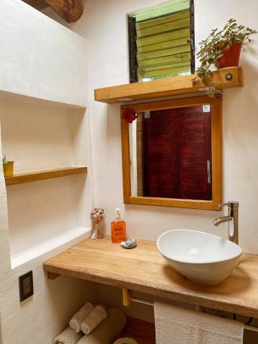 a bathroom with a sink and a mirror at Cabañas Lamaite in Sámara