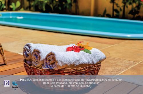 a basket of towels with a flower on it at i9 Quixaba Flat in Itacaré