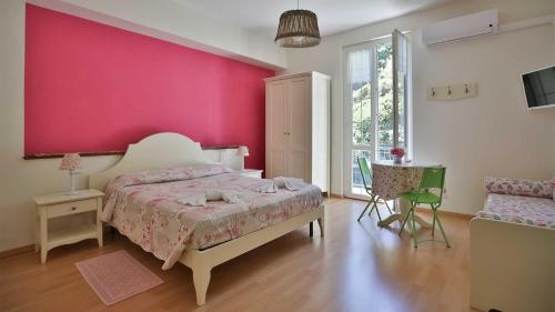 a bedroom with a pink wall and a bed at Ca Lorelei in Riomaggiore