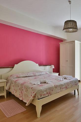 a bedroom with a pink wall and a bed at Ca Lorelei in Riomaggiore