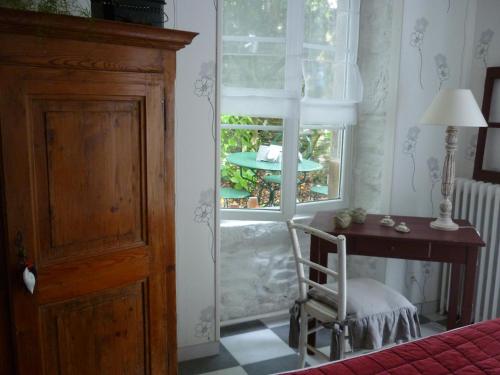sypialnia z oknem z krzesłem i biurkiem w obiekcie La Maison de Claire w mieście Val Couesnon