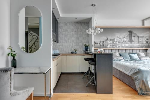 a bedroom and a kitchen with a bed and a desk at Old Town by Welcome Apartment in Gdańsk