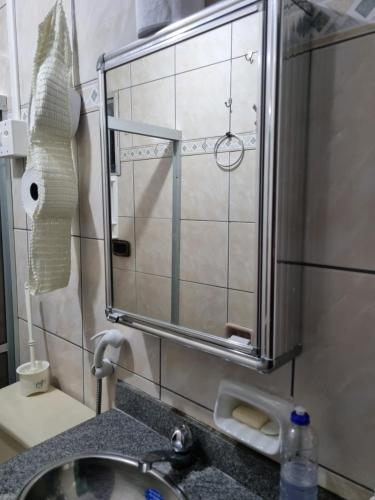a bathroom sink with a mirror over a sink at Salinópolis - Apartamento Varandas do Atlântico in Salinópolis