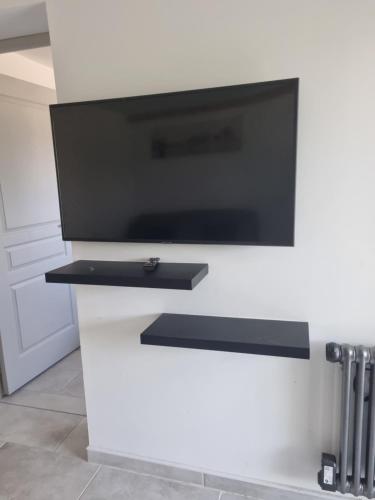 a flat screen tv on a white counter in a kitchen at appartement in Marmande