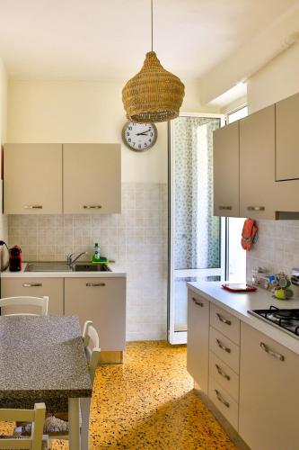 a kitchen with a table and a clock on the wall at Ca Lorelei in Riomaggiore