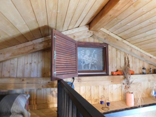 a cabin with a wooden ceiling with a window at Kamnita hiša Stari klesar in Ilirska Bistrica