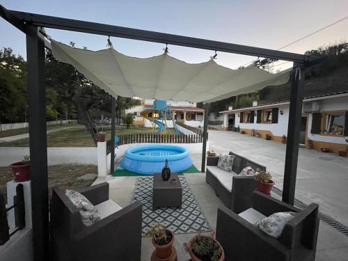 een patio met een witte luifel en een zwembad bij DEl Rey Guest House in Tomar