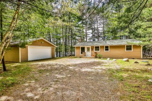 a house with a garage in the woods at Poppa's Paradise in Saint Germain