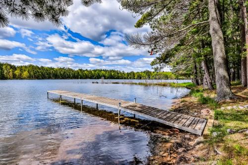 a dock in the middle of a lake with trees at Poppa's Paradise in Saint Germain