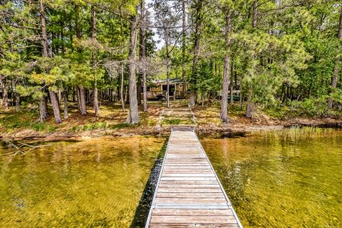 a dock in the middle of a lake with a house at Poppa's Paradise in Saint Germain