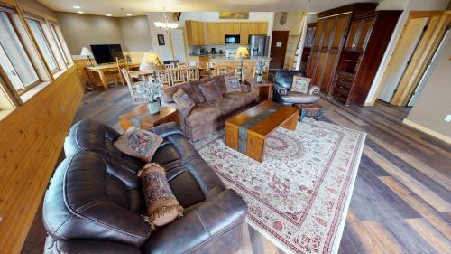 a living room with a leather couch and a table at Gateway Inn in Grand Lake