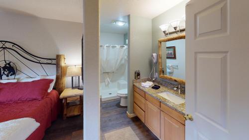 a bedroom with a bed and a bathroom with a sink at Gateway Inn in Grand Lake