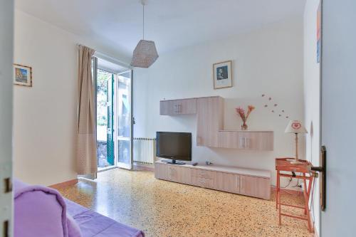 a living room with a flat screen tv and a table at Ca Lorelei in Riomaggiore