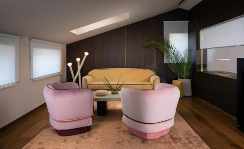 a living room with two pink chairs and a table at Ribarska Koliba Resort in Pula
