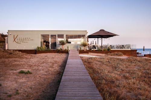 a walkway leading to a building on the beach at Luna Minoica Suites and Apartments in Montallegro
