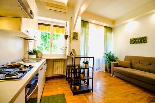 a kitchen with a stove and a couch in a room at PLANT HOUSE Roma Eur in Rome