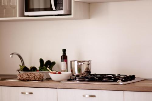 a kitchen counter with a stove and a microwave at Luna Minoica Suites and Apartments in Montallegro