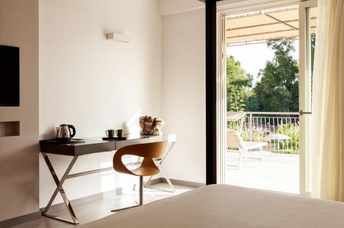 a bedroom with a desk and a chair next to a sliding glass door at Luna Minoica Suites and Apartments in Montallegro
