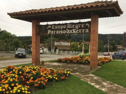 a sign for a parking lot with flowers at Casa aconchegante no Centro de Campo Alegre(SC) in Campo Alegre