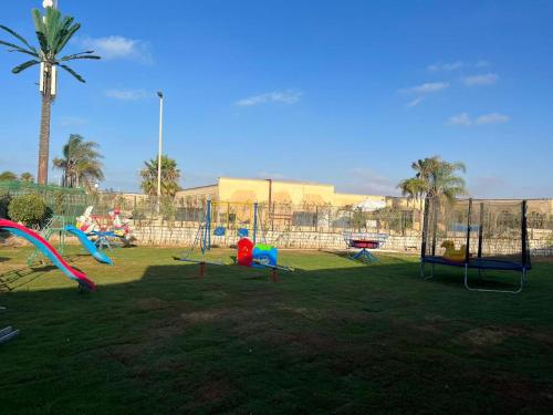 a park with a bunch of playground equipment in the grass at Le Royal Marina Hotel in El Alamein