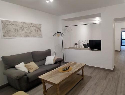 a living room with a couch and a coffee table at Castella Aquae II Amplio loft para dos in Merida