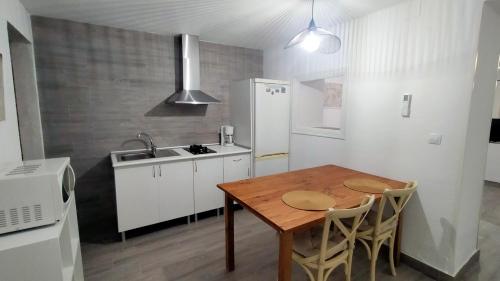 a small kitchen with a wooden table and a sink at Castella Aquae II Amplio loft para dos in Merida