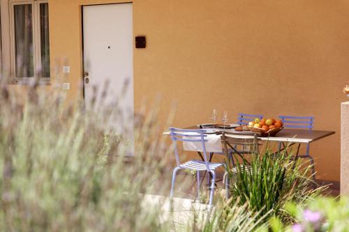 a table with chairs and a plate of fruit on it at Luna Minoica Suites and Apartments in Montallegro