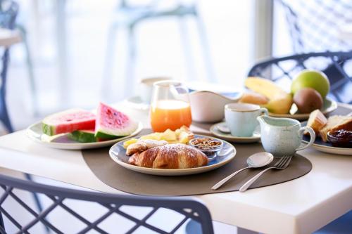 a table with plates of breakfast food on it at Luna Minoica Suites and Apartments in Montallegro