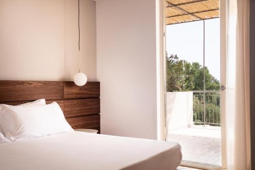 a bedroom with a bed and a large window at Luna Minoica Suites and Apartments in Montallegro