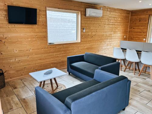 sala de estar con sofá, sillas y TV en chalet des Illes MADAGASGAR II, en Prat-et-Bonrepaux