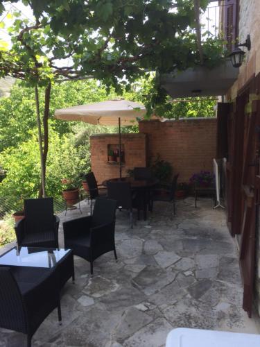 a patio with tables and chairs and an umbrella at AYIOS NICOLAOS RIVER PARK in Perapedhi
