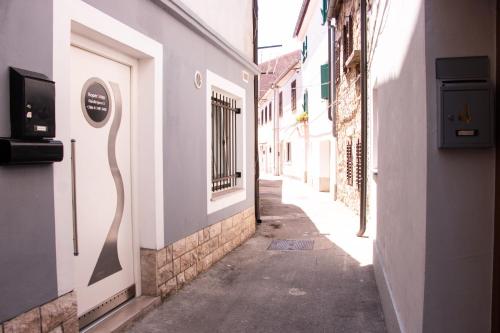 a narrow alley with a sign on the side of a building at Koper2stay Apartments in Koper
