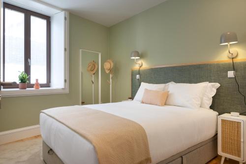 a bedroom with a large white bed and a window at Away to Enjoy Apartment - hapiness has a place in Porto