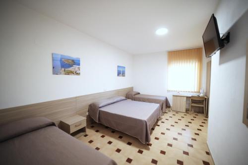 Cette chambre comprend deux lits et une télévision. dans l'établissement Petracuzza casa vacanze, à Tortora