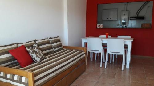 a living room with a couch and a table with white chairs at Espacio C Av Poeta Lugones GRAN VISTA in Córdoba