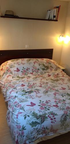 - un lit avec une couverture fleurie dans l'établissement Mobil Home Lacanau Océan, à Lacanau