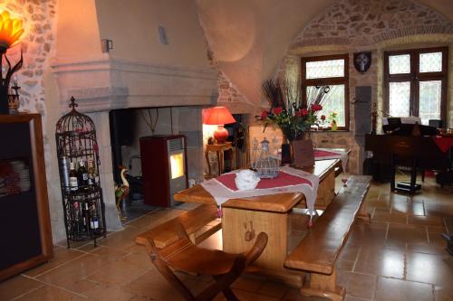 ein Wohnzimmer mit einem Tisch und einem Kamin in der Unterkunft Château des Aiguilles in Saint-Rémy-de-Chargnat