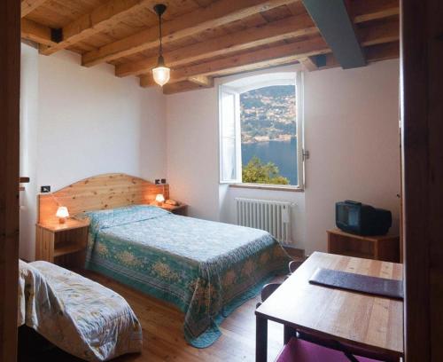 a bedroom with a bed and a window and a table at Ristorante Hotel Falchetto in Brunate