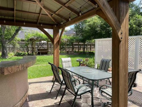 a patio with a table and chairs under a wooden pergola at New decorated Guest Suite unit C close to Katy Mills in Katy