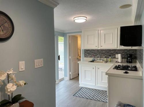 a kitchen with white cabinets and a clock on the wall at New decorated Guest Suite unit C close to Katy Mills in Katy