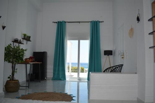 een woonkamer met een glazen schuifdeur met uitzicht op de oceaan bij Maistrali in Provatas