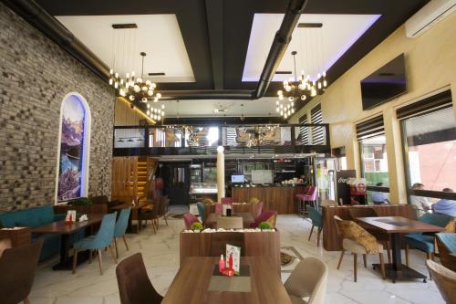 a restaurant with tables and chairs and a brick wall at B H B Apartmani in Novi Pazar