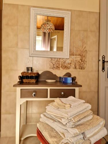 a pile of towels sitting on a table in a bathroom at Chambres d'hôtes Villa bella fiora in Biguglia