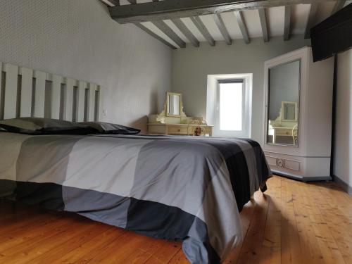 una camera con un grande letto e uno specchio di Aux belles pierres a Carcagny