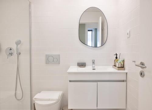 a white bathroom with a sink and a mirror at Away to Enjoy Apartment - hapiness has a place in Porto