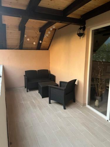 a patio with a couch and chairs on a porch at Zavojsko jezero - Vila Jezero in Pirot